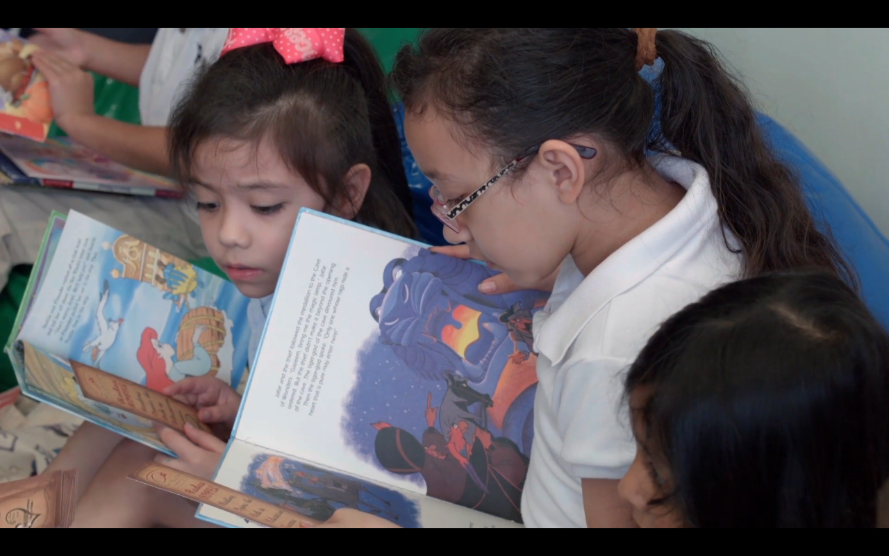 Two kids reading books.