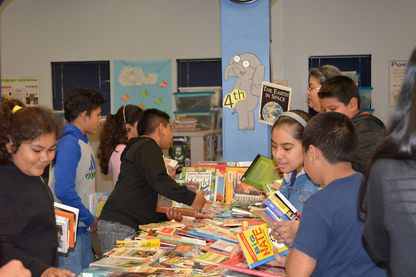 Kids choosing books at a table.